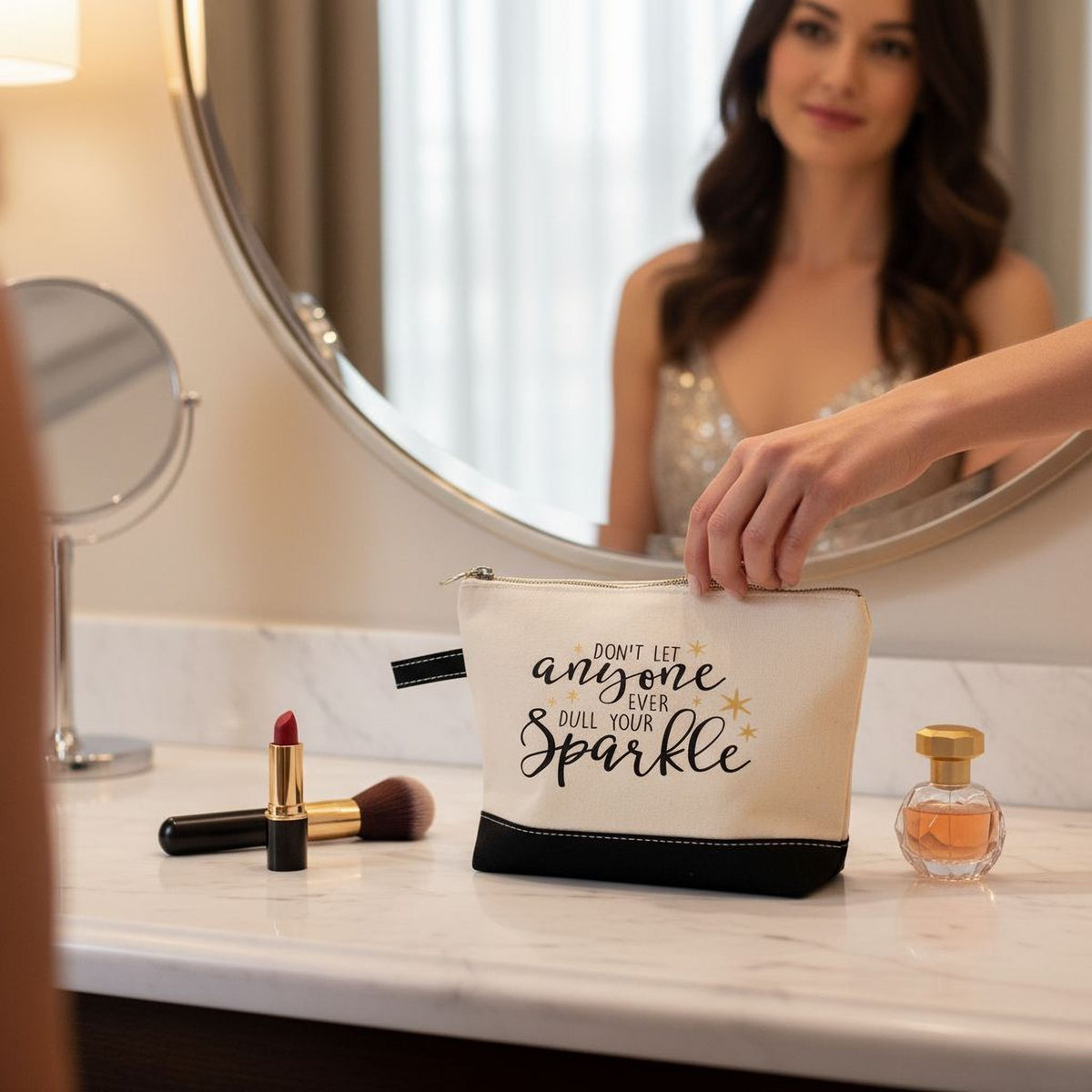 Beige canvas cosmetic bag with black bottom, zipper and ring pull; 'anyone ... Sparkle' text.