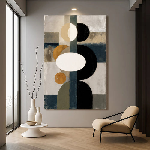 Abstract geometry wall art with black curved forms and blue, tan blocks on a neutral panel