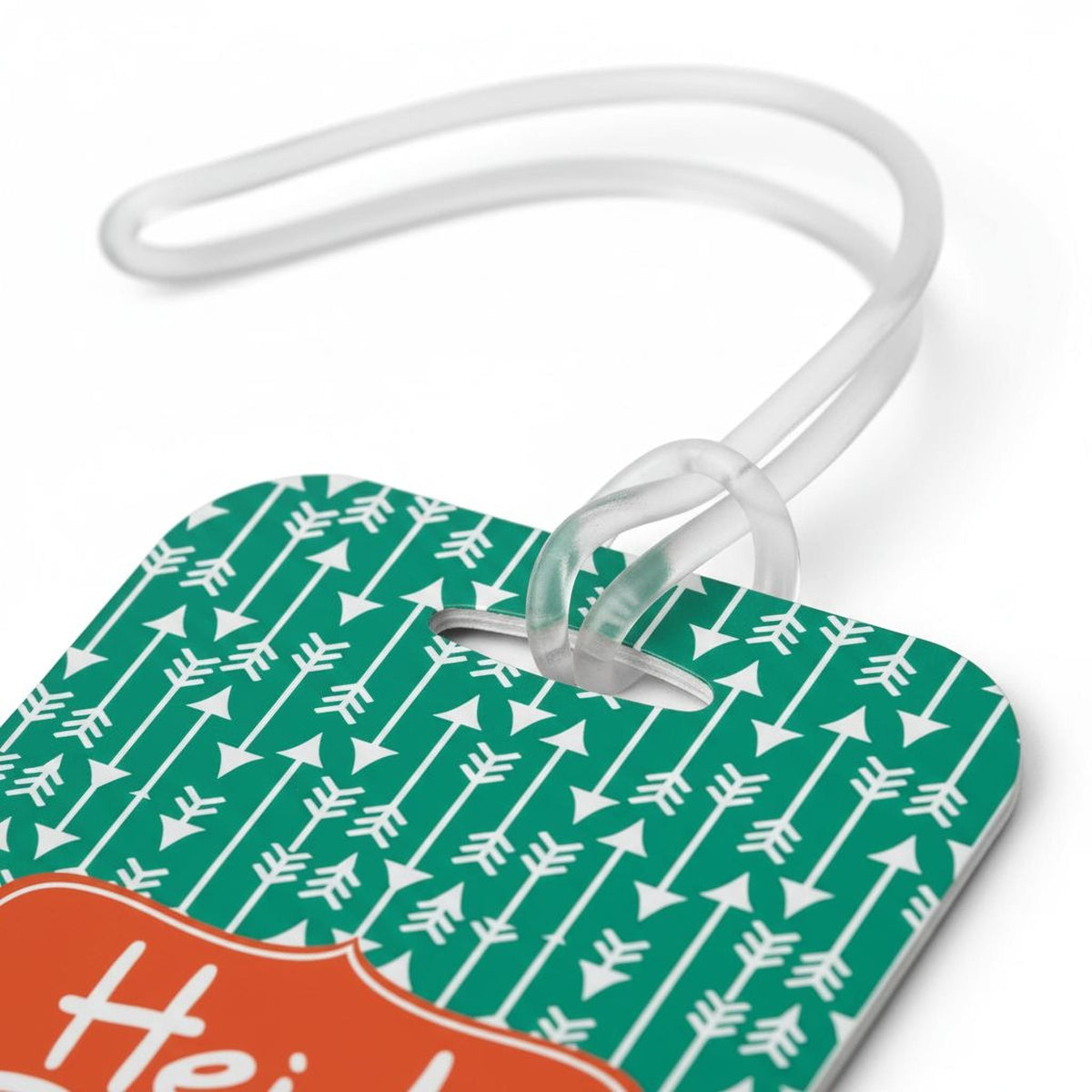 Green patterned bag tag corner with white icons and orange name strip tied in white cord
