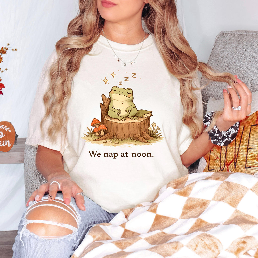 Off-white frog T-shirt with sleeping frog on stump and “We nap at noon.” print