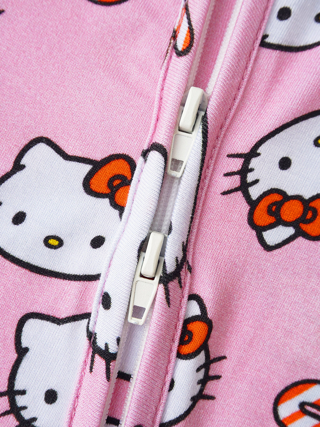 Pink baby romper front zipper close-up with Hello Kitty print