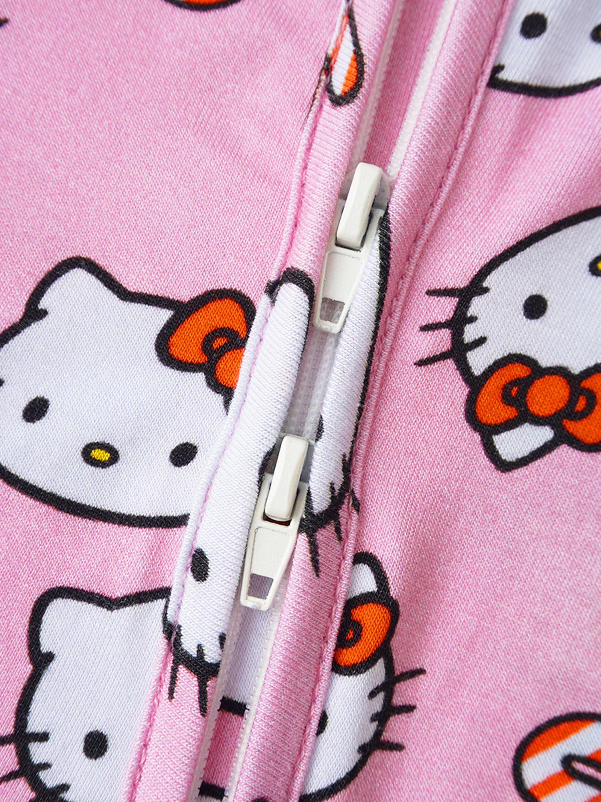 Pink baby romper front zipper close-up with Hello Kitty print
