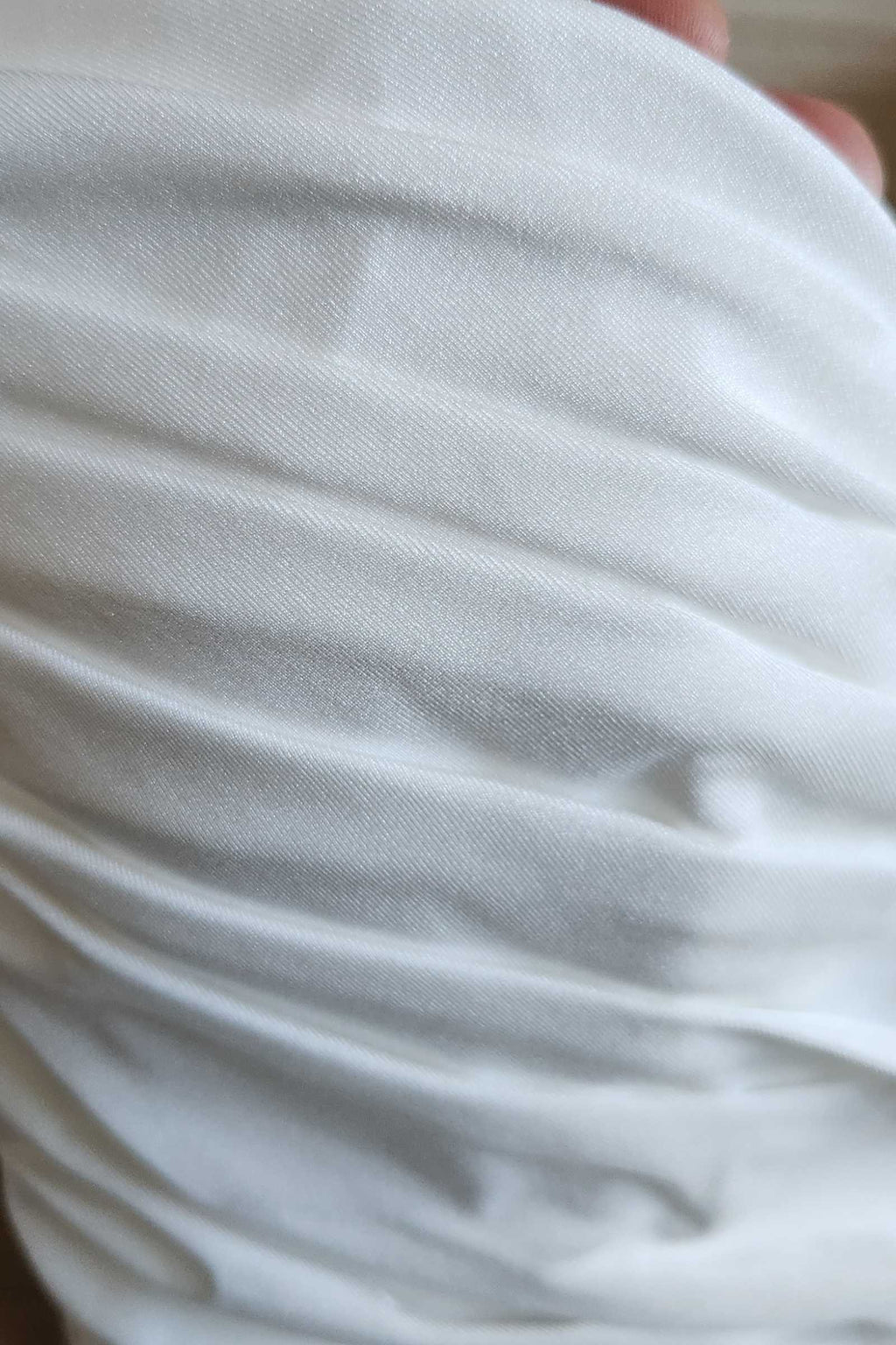 Off-white bridal gown fabric with soft pleats and drape