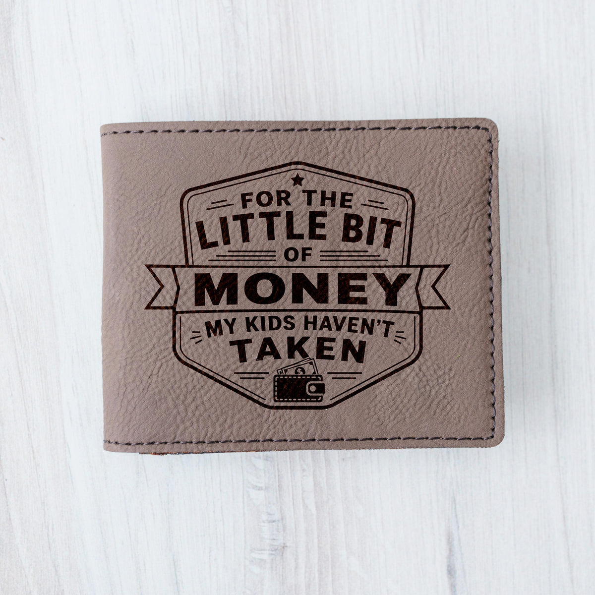 Brown leather bifold wallet front view with engraved “For the little bit of money”