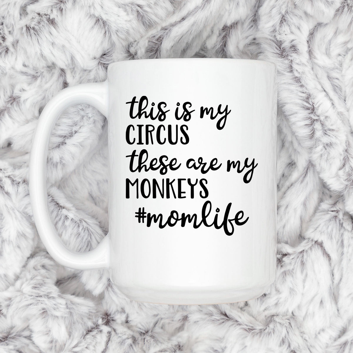 White ceramic coffee mug on gray faux-fur with "Circus" momlife message