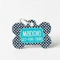 Navy dog ID tag with large white dots, teal nameplate, and metal attachment ring