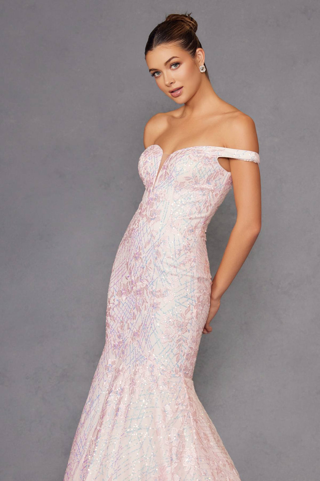 Blush mermaid gown with off-shoulder neckline and fitted sparkle fabric, side profile.