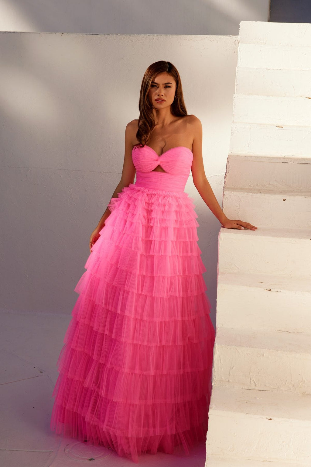 Neon pink strapless tiered tulle A-line gown with bow-tied bodice