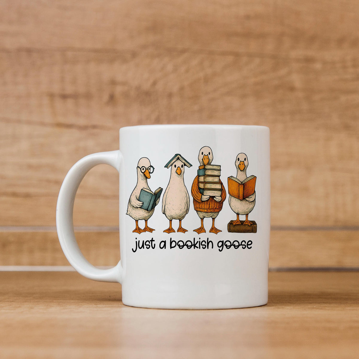 White ceramic coffee mug with bookish goose illustration and "just a bookish goose" text