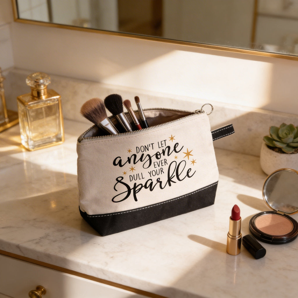 Beige canvas makeup pouch with black bottom and zipper; 'anyone ... Sparkle' slogan.