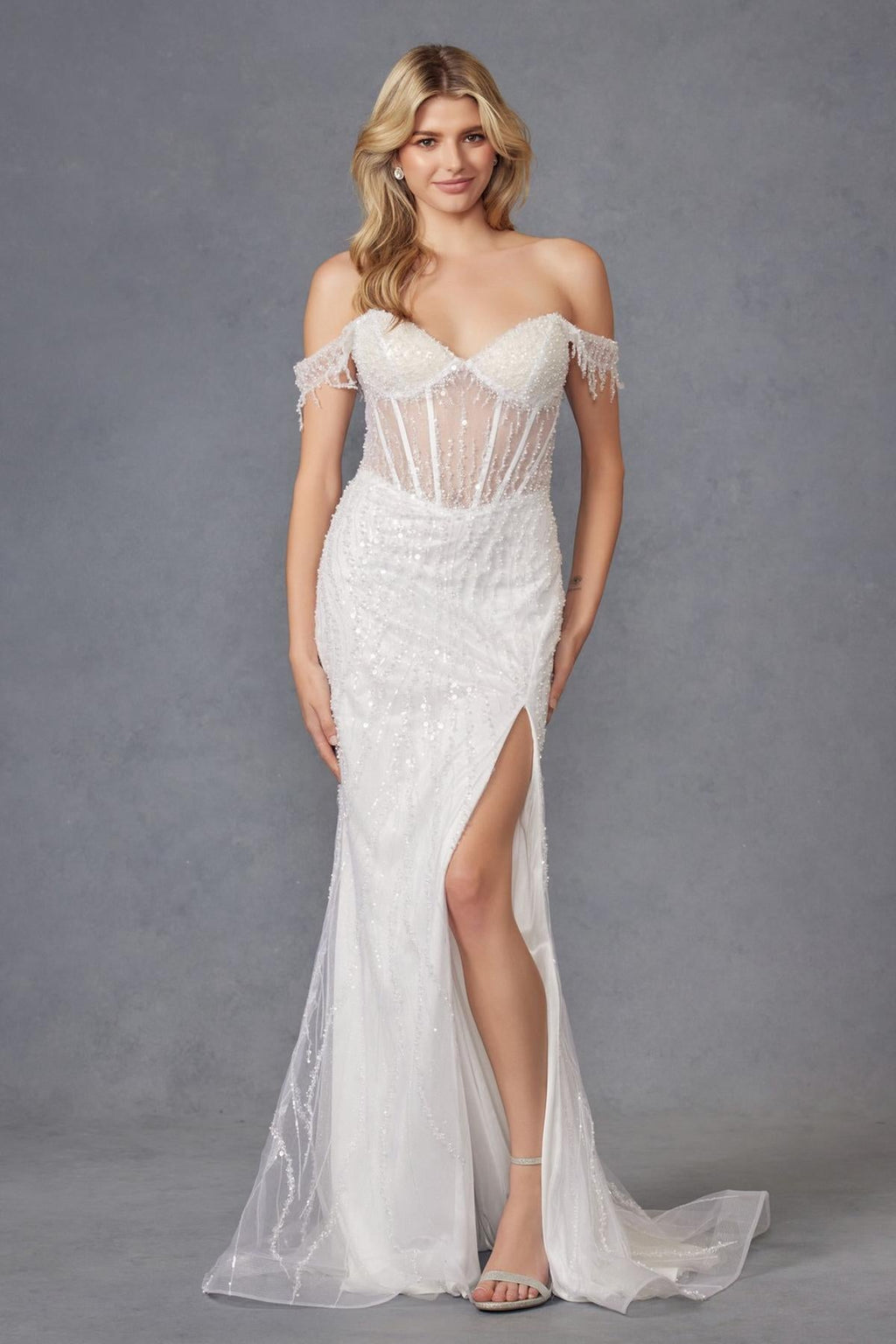 Off-white off-shoulder fitted wedding gown with corset bodice, fringe sleeves, and leg slit