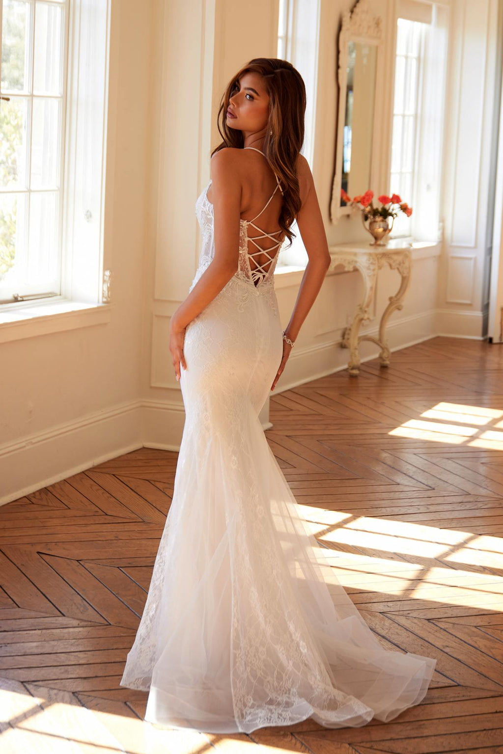 Off-white lace mermaid bridal dress with spaghetti straps and open lace back detail.