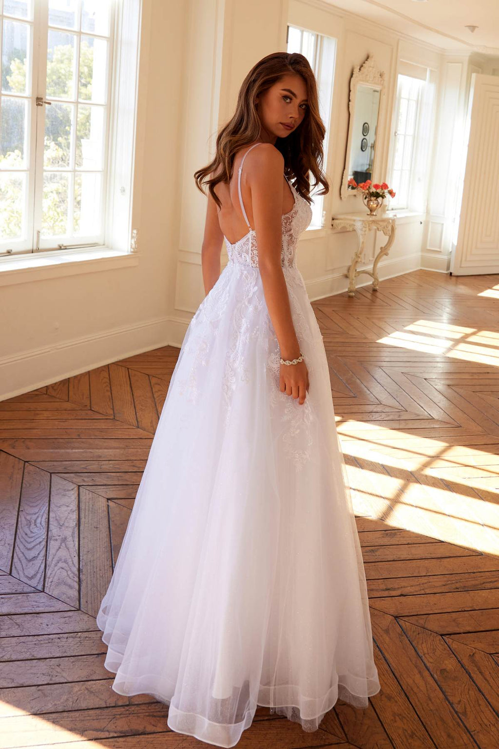 White A-line lace wedding gown with thin straps and layered tulle hem