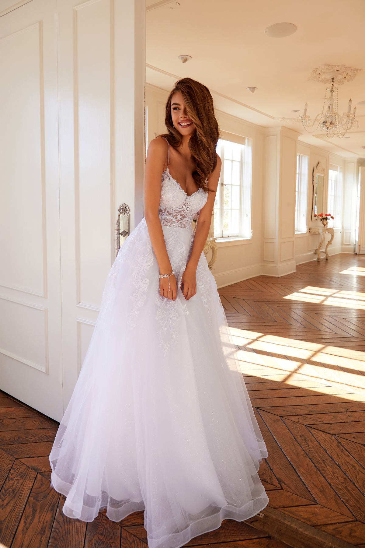 White lace corset-style bodice with thin straps and full tulle ball gown skirt