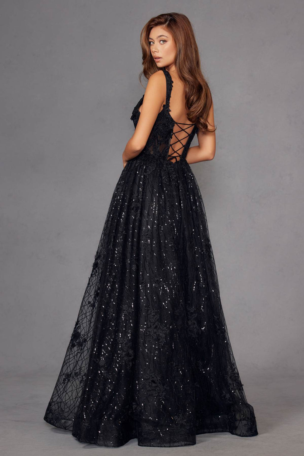 Black A-line evening gown with crisscross back straps and full glitter skirt