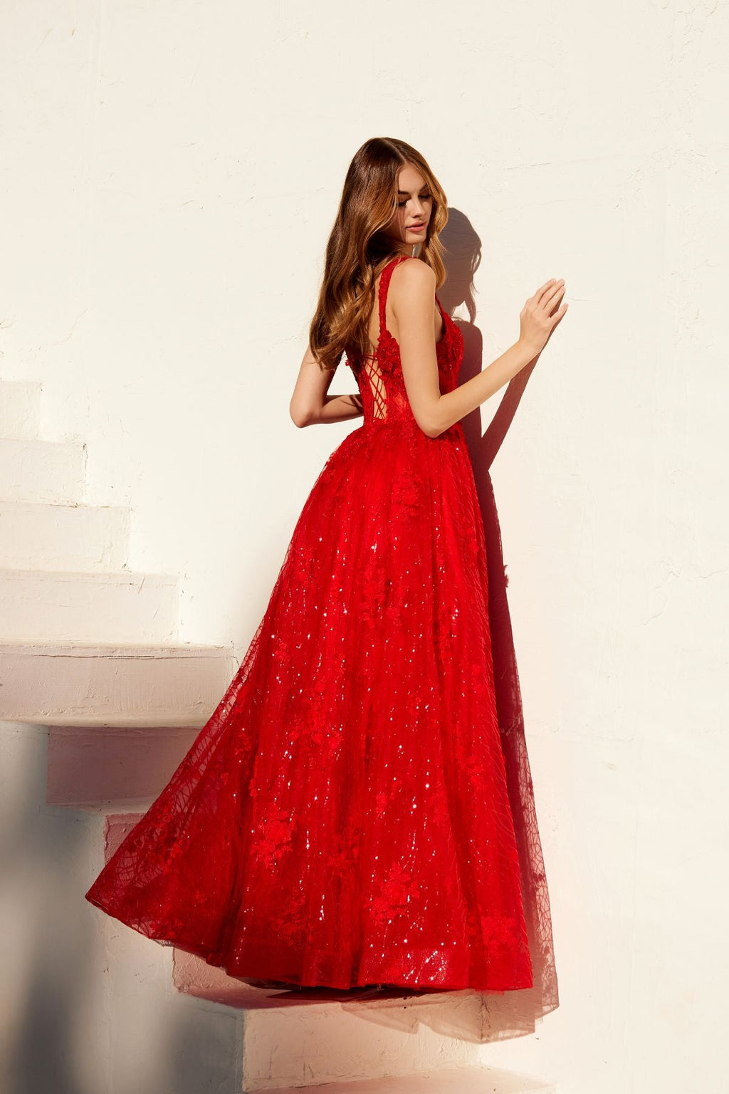 Red A-line evening gown with V-neckline, lace-like texture, and flared skirt