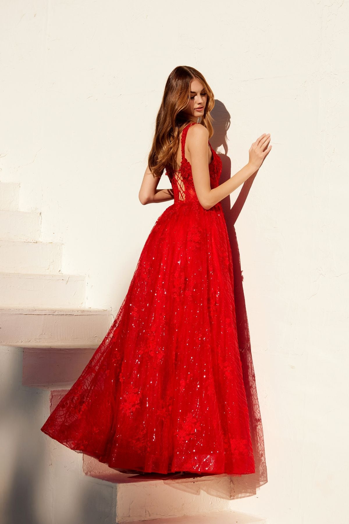 Red A-line evening gown with V-neckline, lace-like texture, and flared skirt