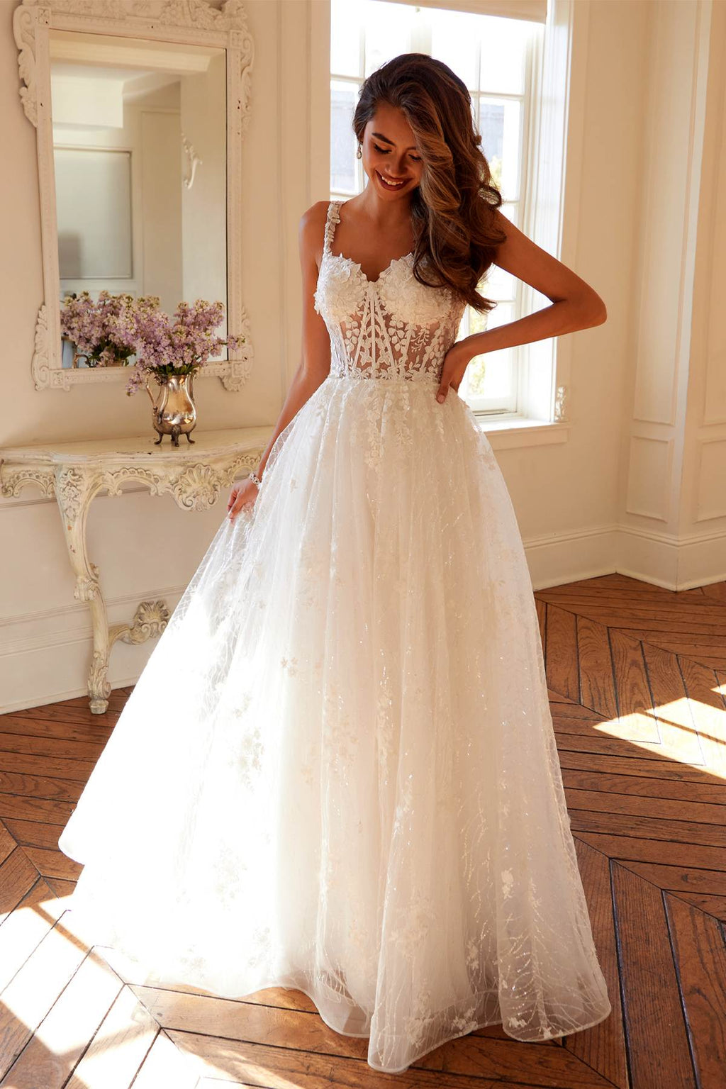 Off-white long A-line bridal gown with floral lace bodice and scalloped skirt hem