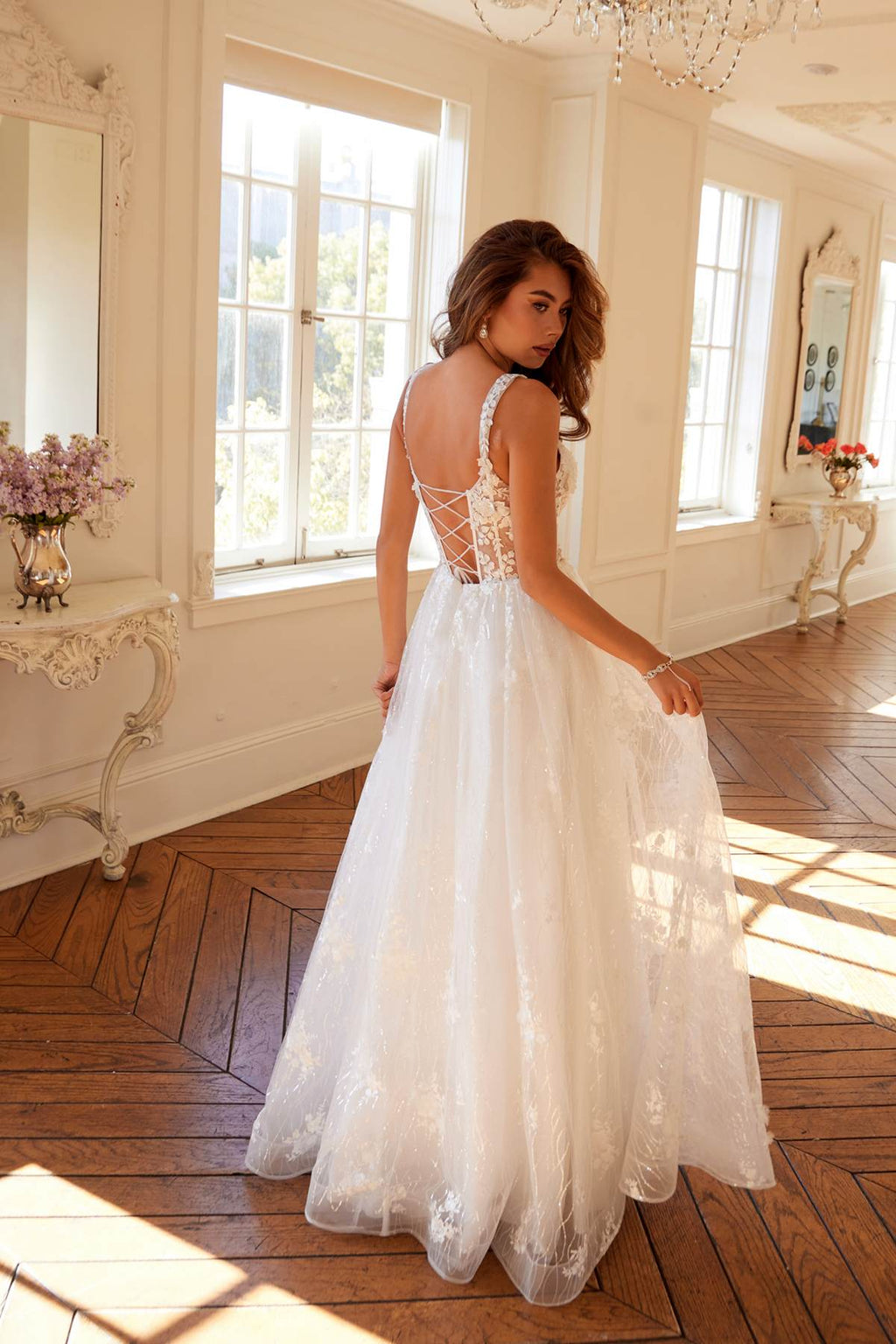 Off-white long A-line bridal gown with lace illusion back and delicate floral appliques