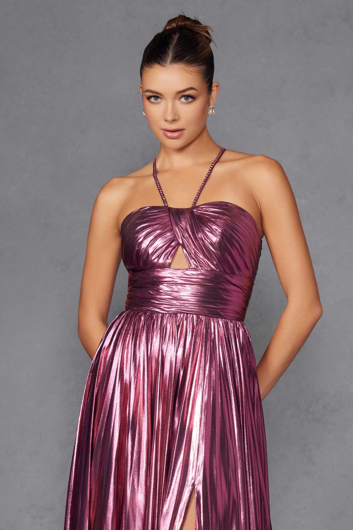 Metallic halter A-line gown in berry with ruched bust and pleated skirt details