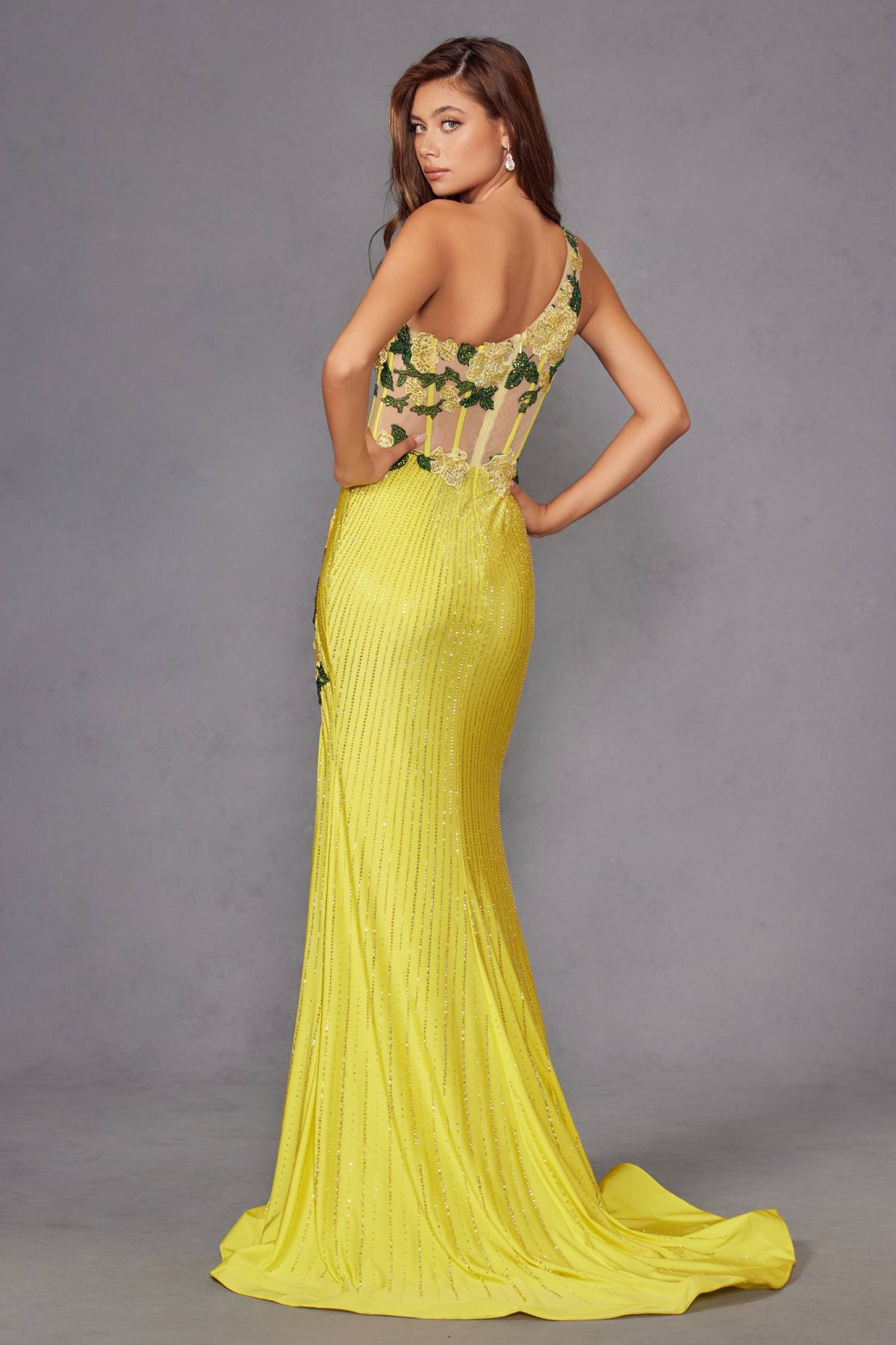 Back view of one-shoulder fitted evening gown in bright yellow with floral applique