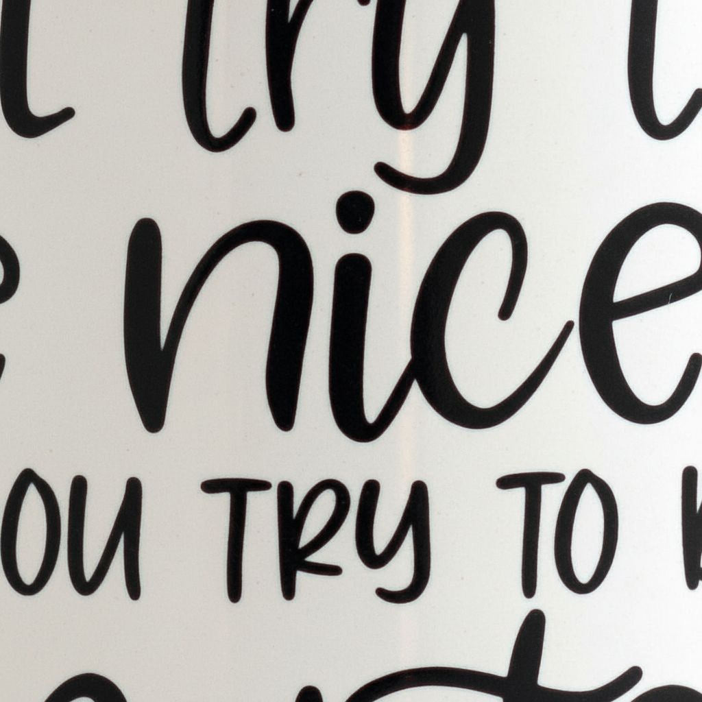 White mug close-up with black lettering: 'try to be nicer' and 'try to be smarter'.