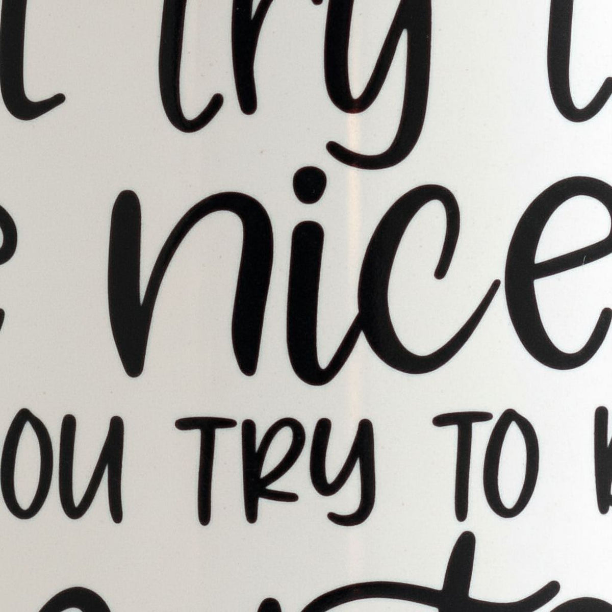 White mug close-up with black lettering: 'try to be nicer' and 'try to be smarter'.
