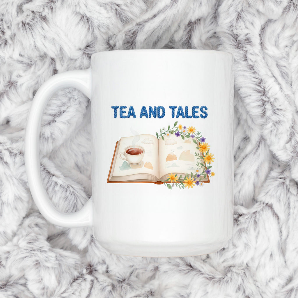 White ceramic mug with "TEA AND TALES" text and book/flower illustration on front