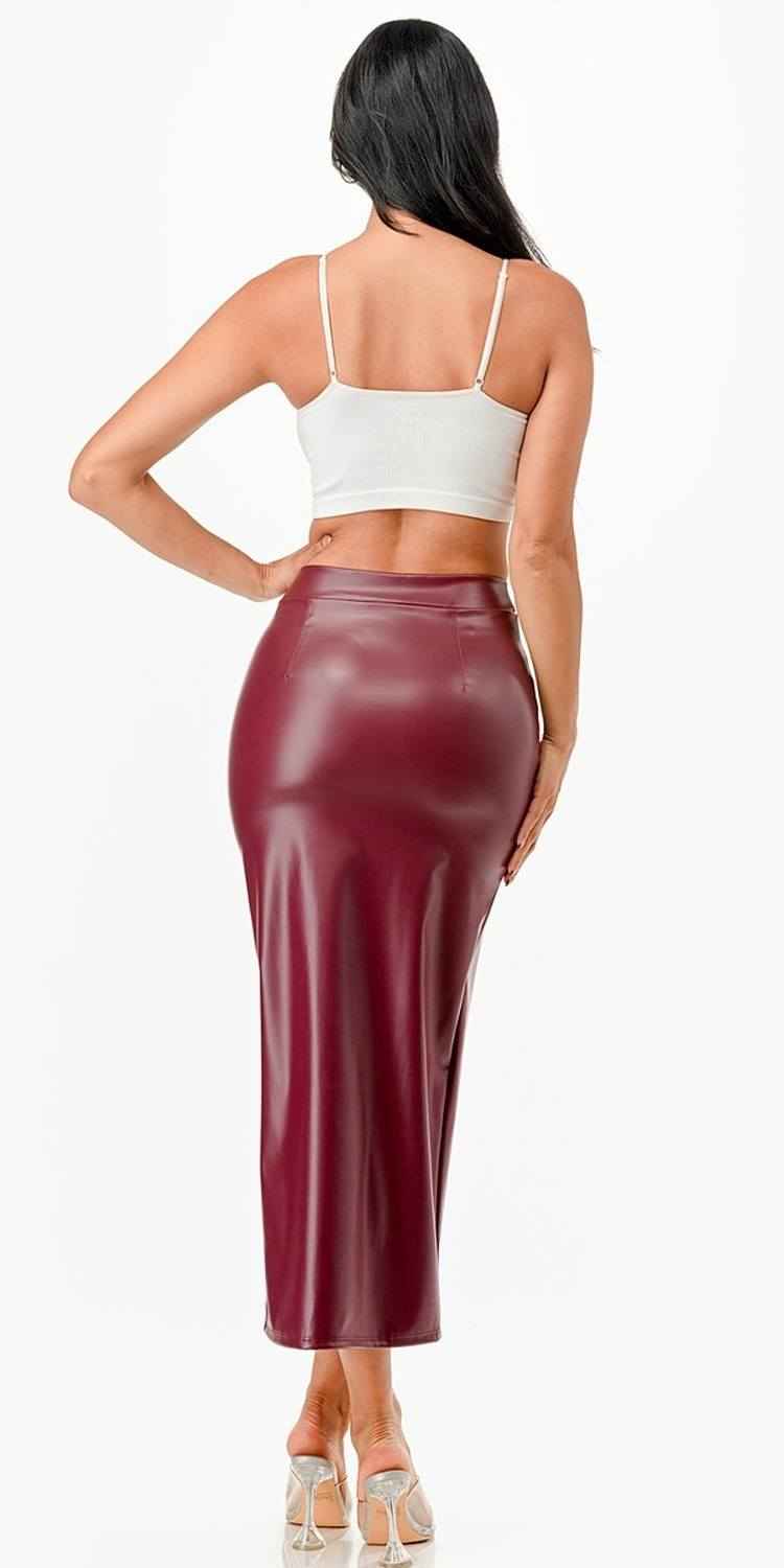 Mid-length burgundy faux leather pencil skirt with a slit and back seam shaping.