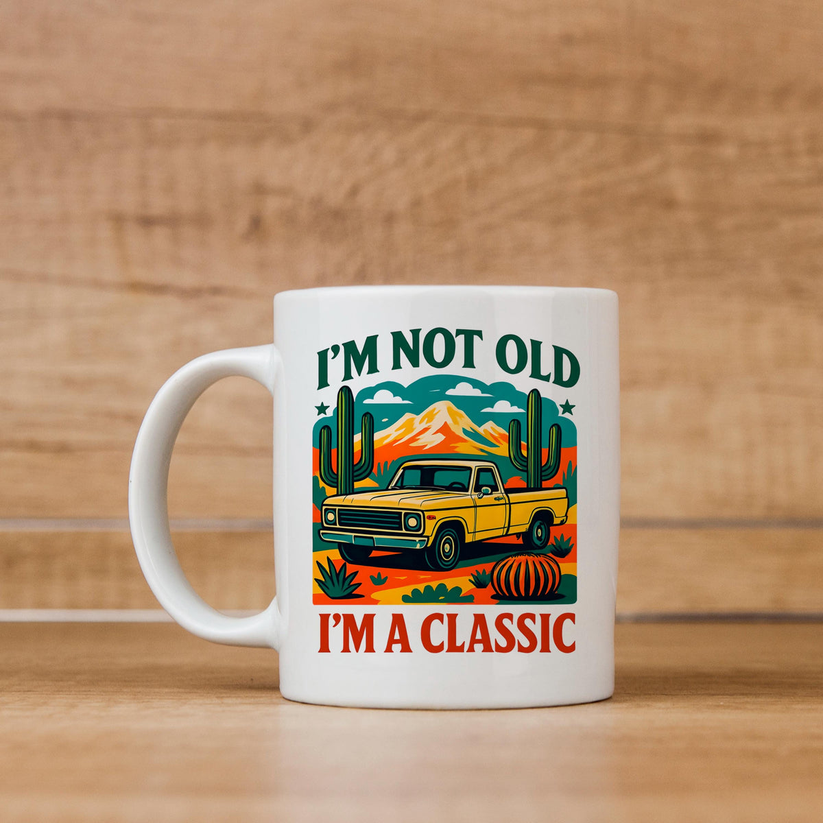 White ceramic mug with vintage car and desert cacti graphic; “I’m not old, I’m a classic” text.