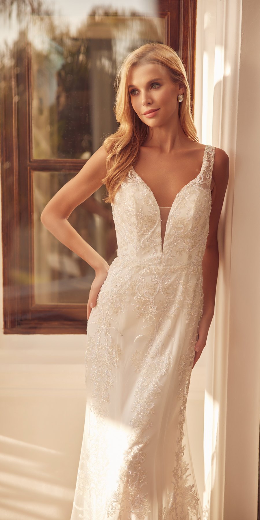 Off-white mermaid wedding dress with sleeveless V-neck and floral lace detailing
