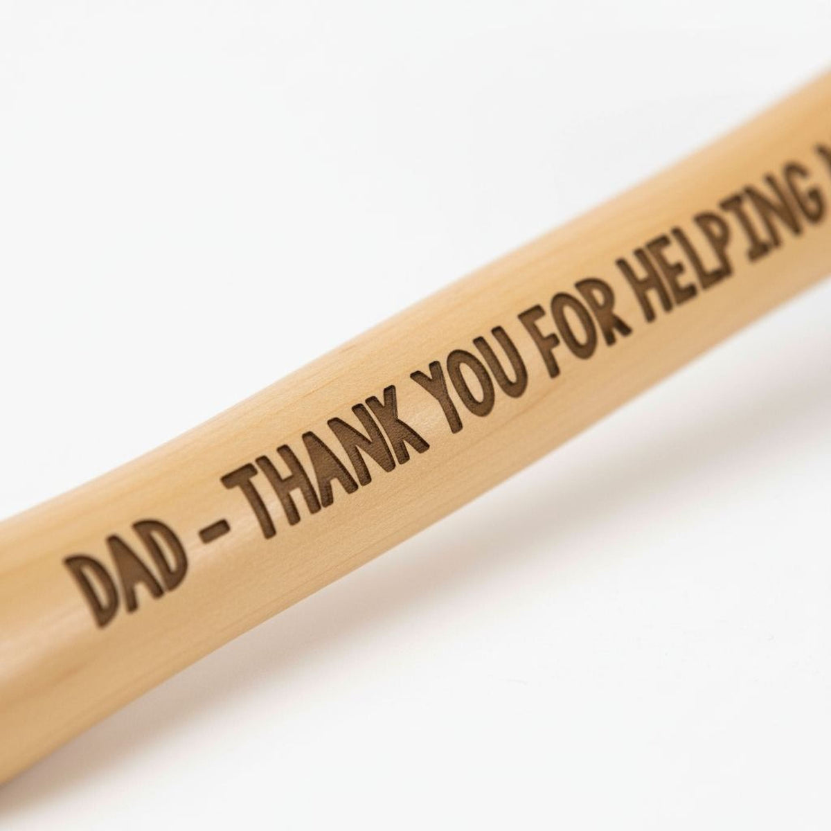 Close-up of engraved light wood hammer handle with “DAD - THANK YOU FOR HELPING…”