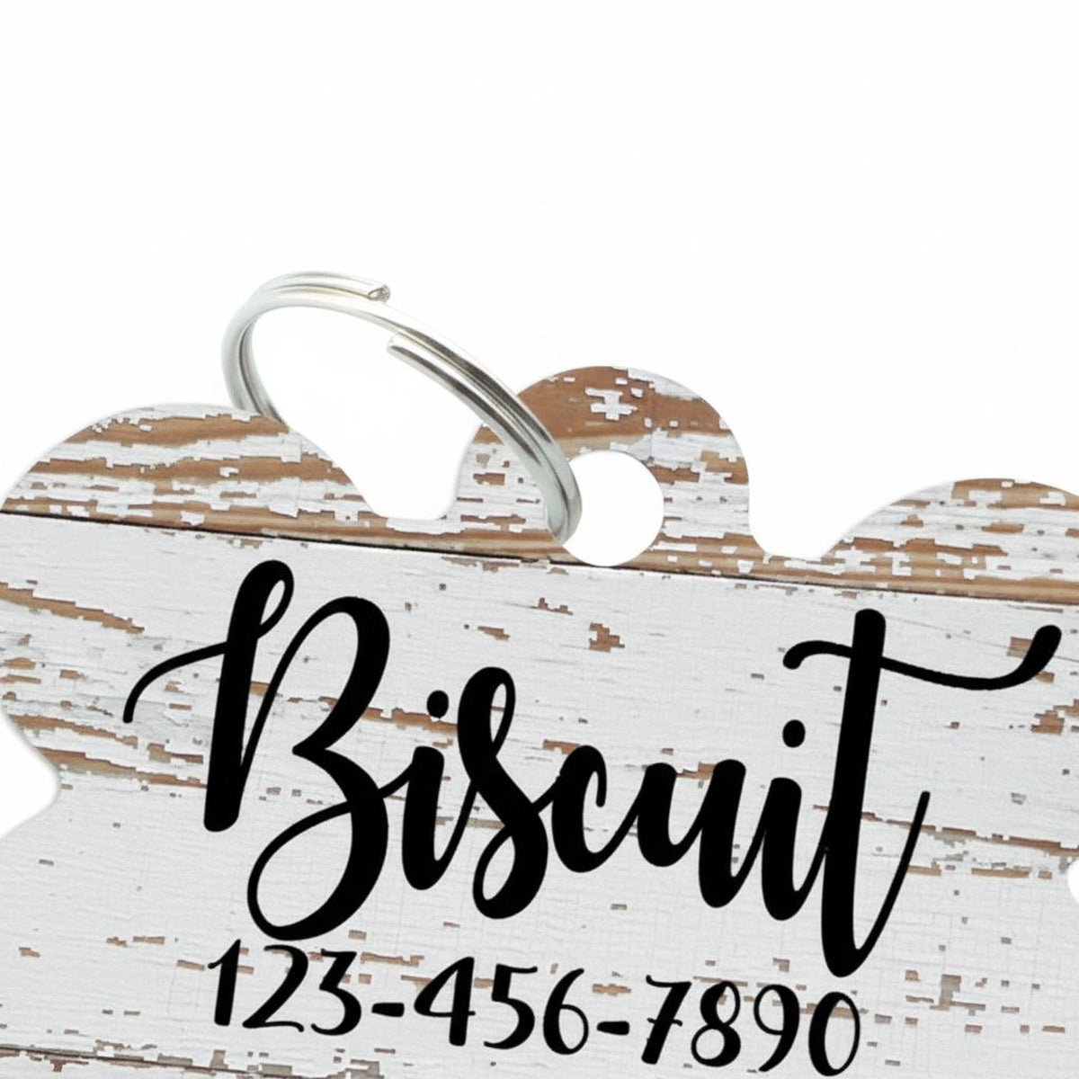 Woodgrain-style pet ID tag in bone shape with engraved Bisquit and phone number
