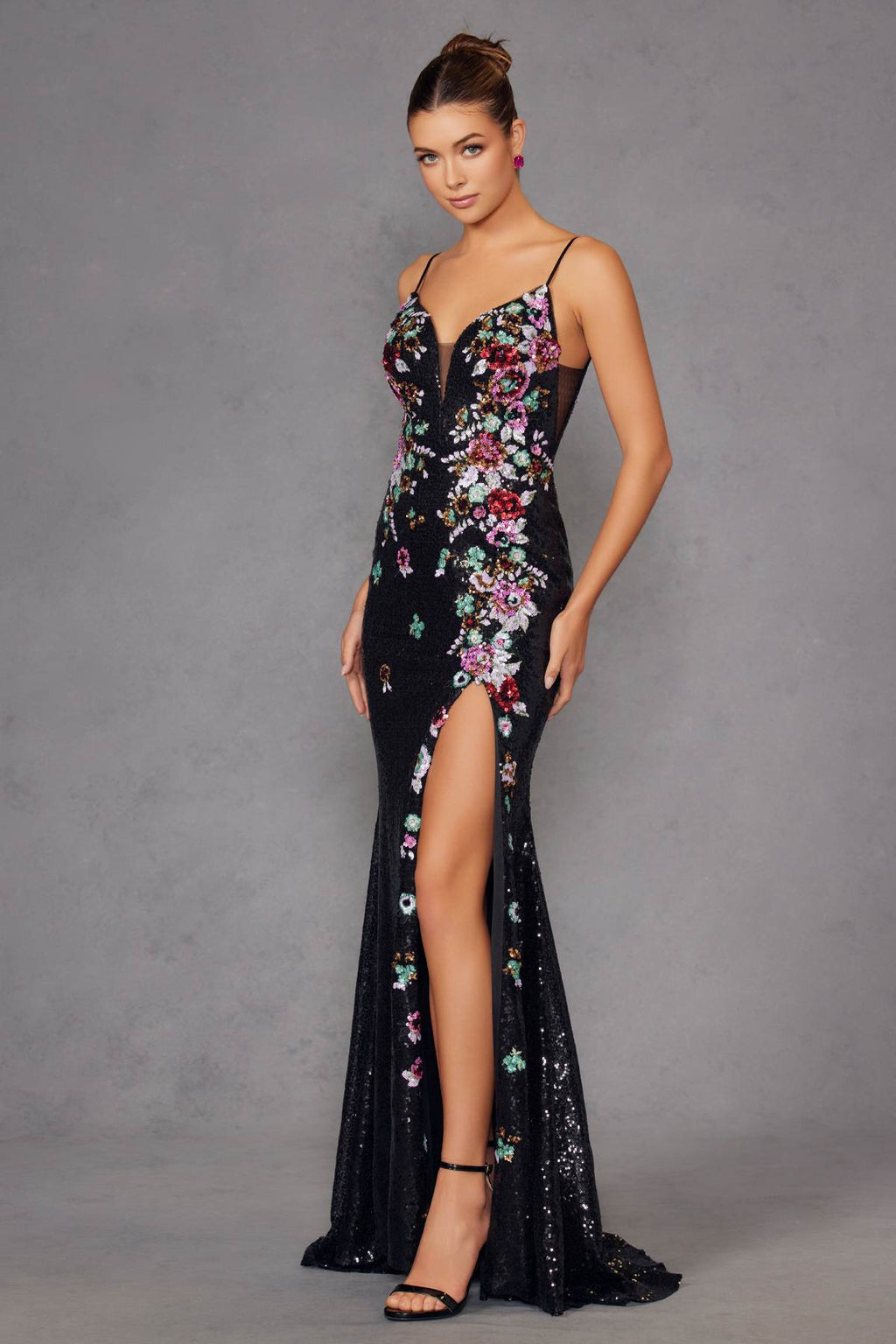 Black fitted prom gown with floral embroidery and sequins, spaghetti straps, front slit.
