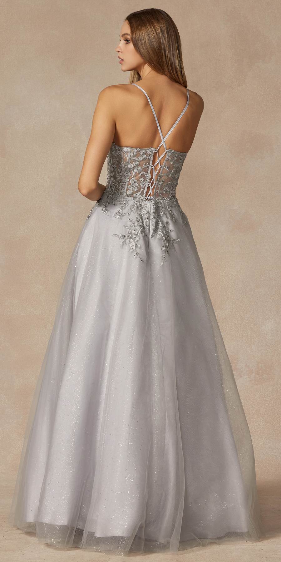 Silver corset prom gown back view with crisscross straps and leaf lace detailing.