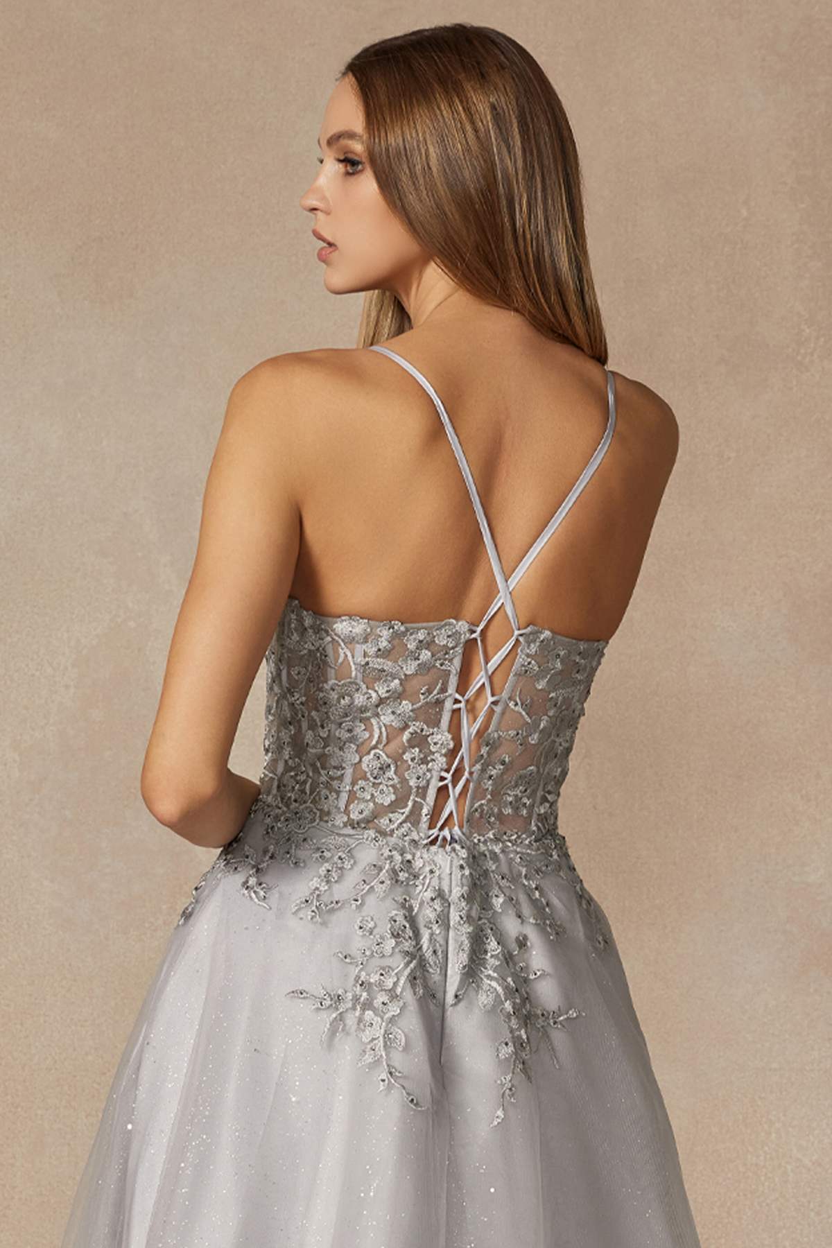 Silver leaf lace prom gown with crisscross back straps and spaghetti straps.