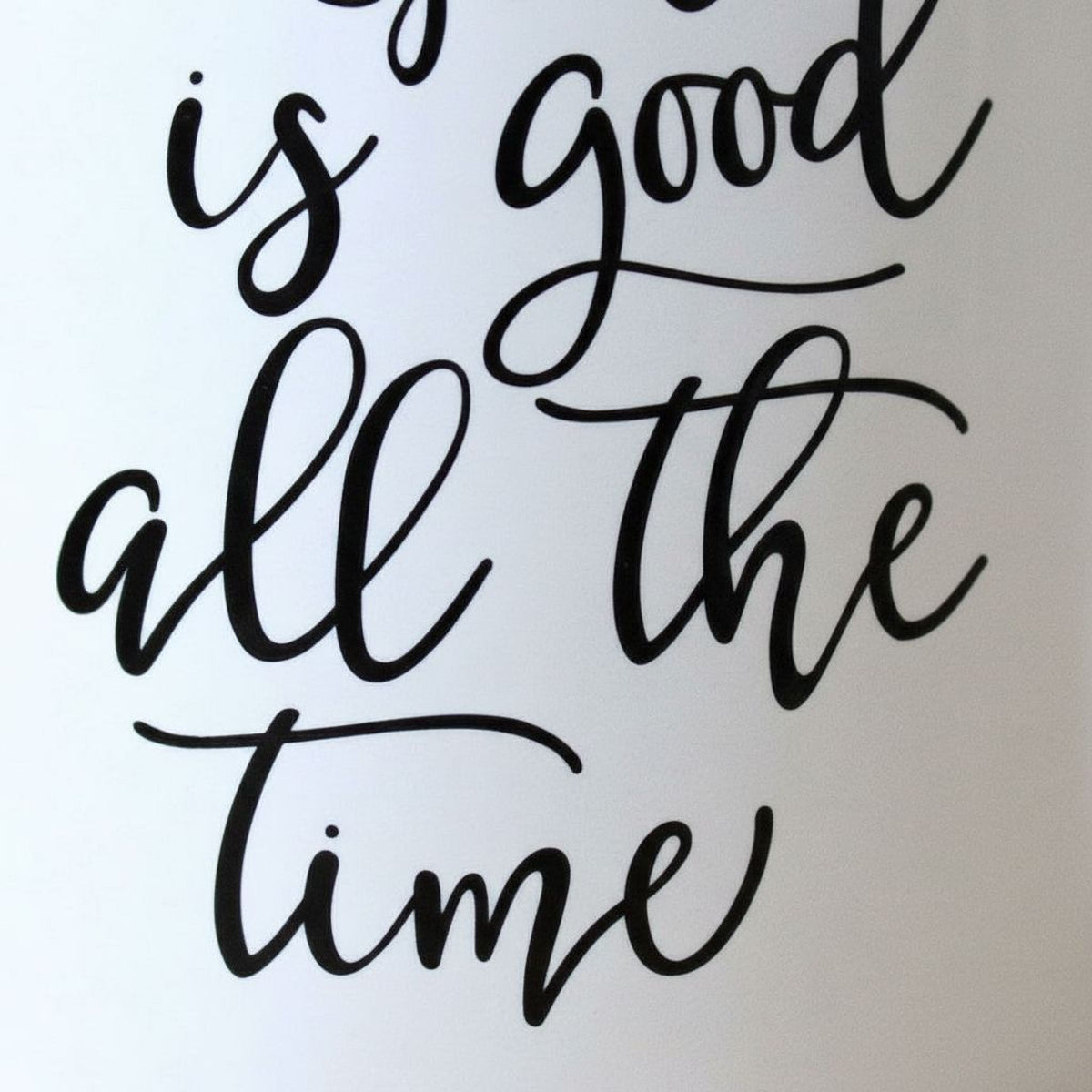 Close-up of white ceramic mug with 'God is good all the time' lettering