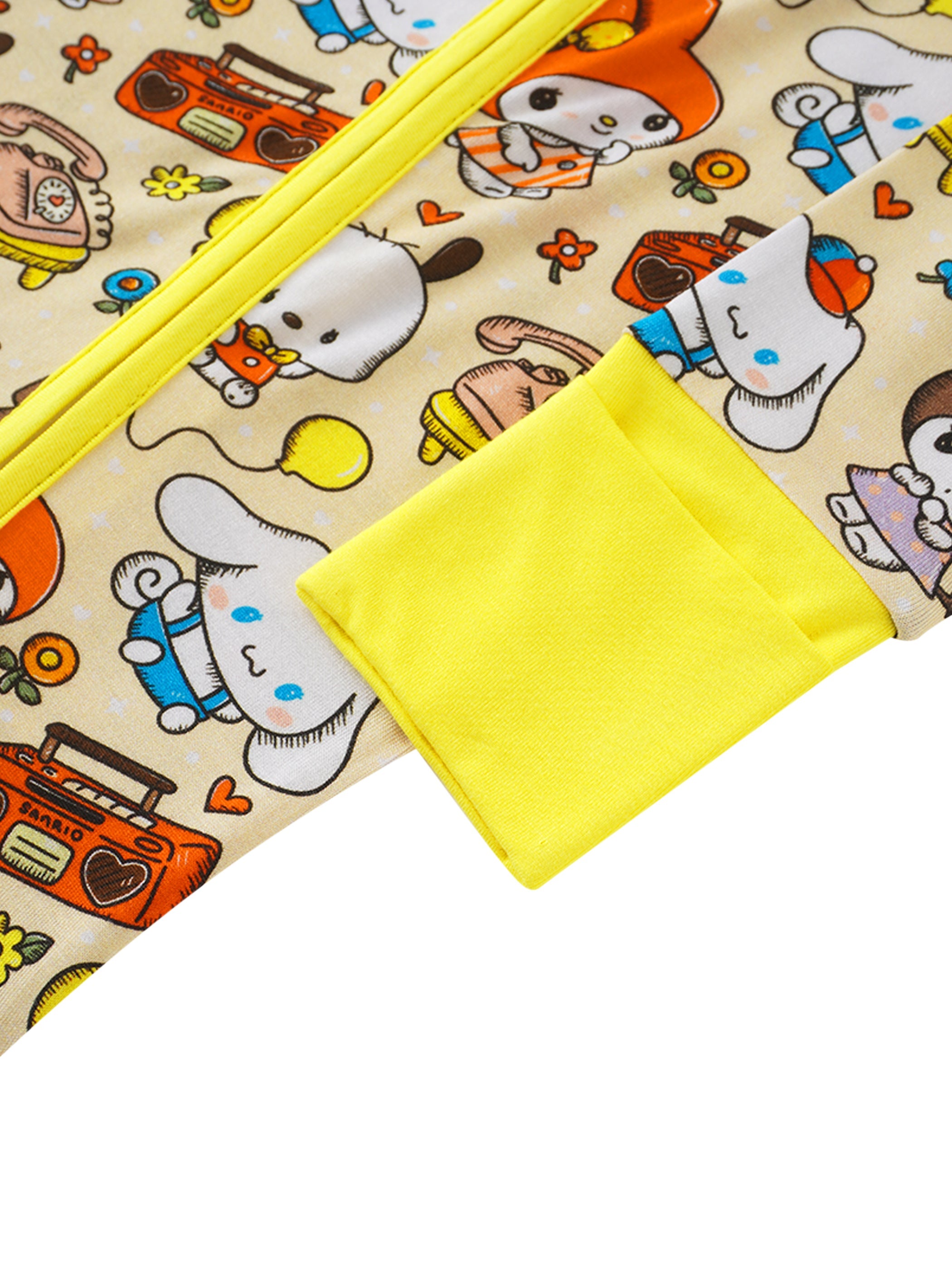 Baby romper close-up with yellow cuffs and character print; diagonal zipper seam detail