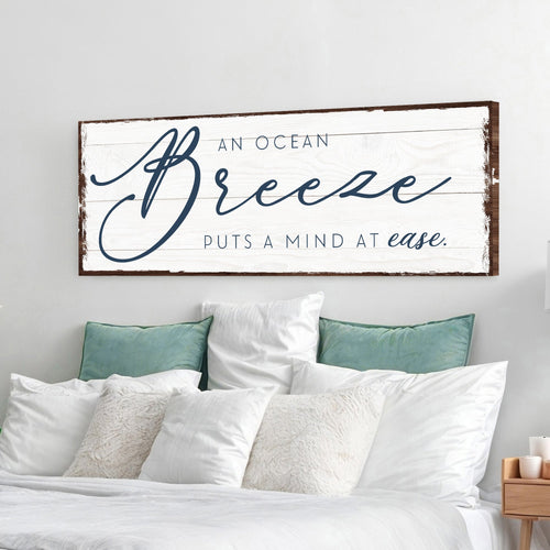 Ocean Breeze wall sign with white canvas, blue script text, and dark wood frame