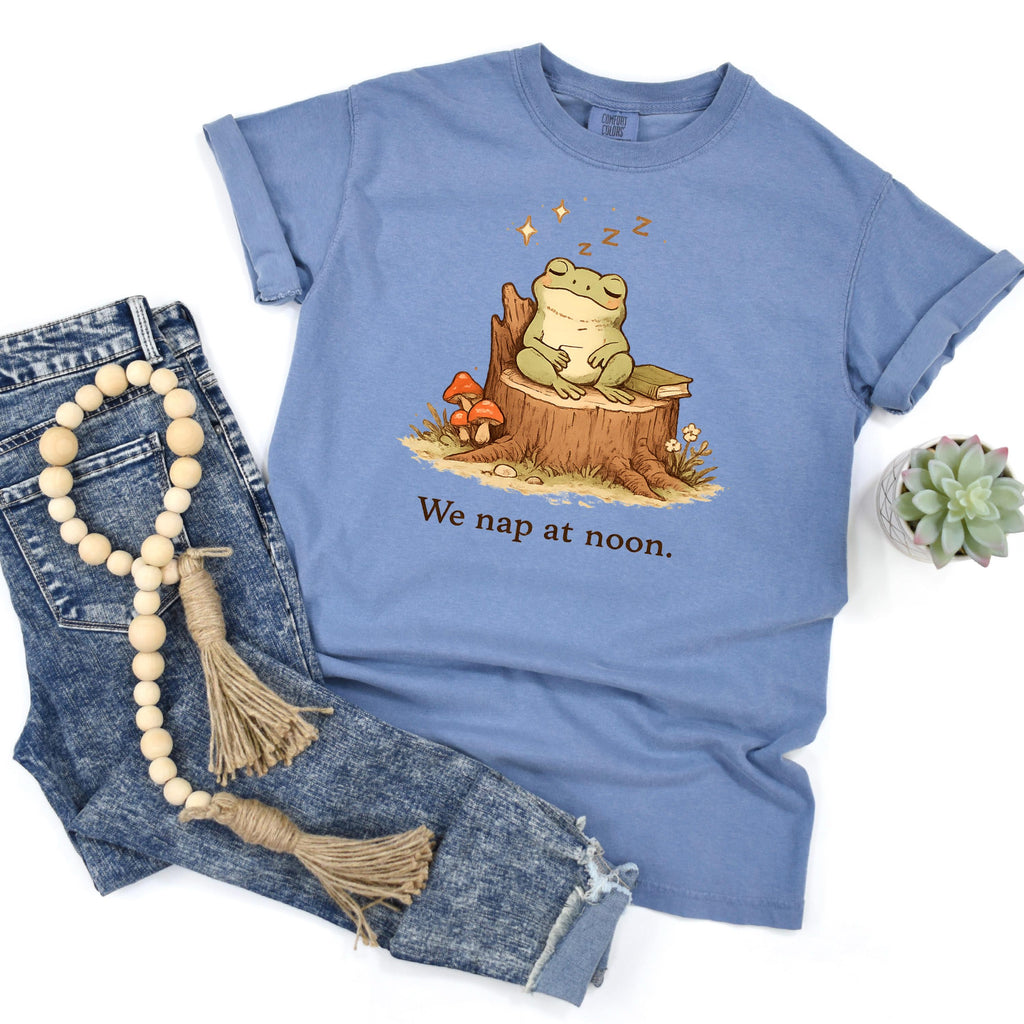 Light blue frog T-shirt with sleeping frog on stump and “We nap at noon.” print