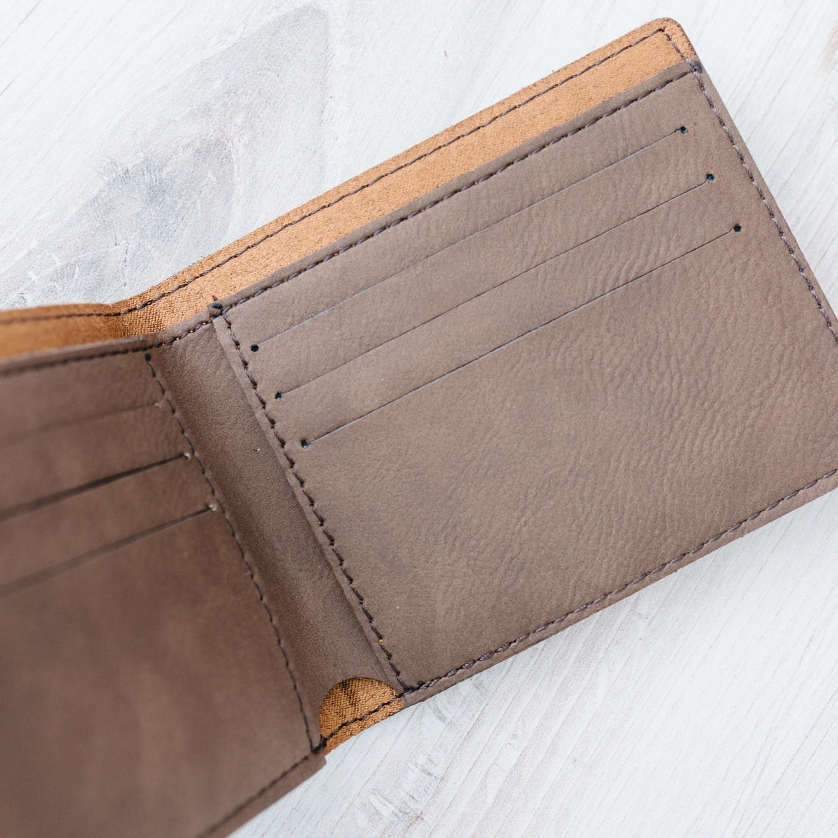 Brown leather slim bifold wallet interior with stitched card slots, top edge visible