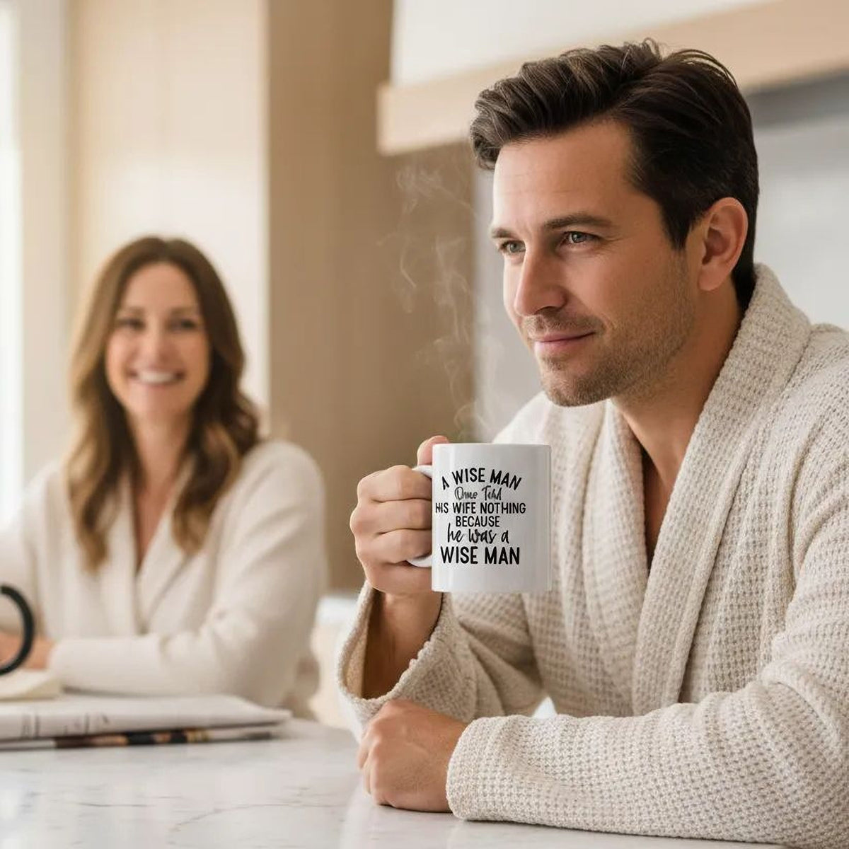 White ceramic coffee mug with "A WISE MAN" quote, held in one hand