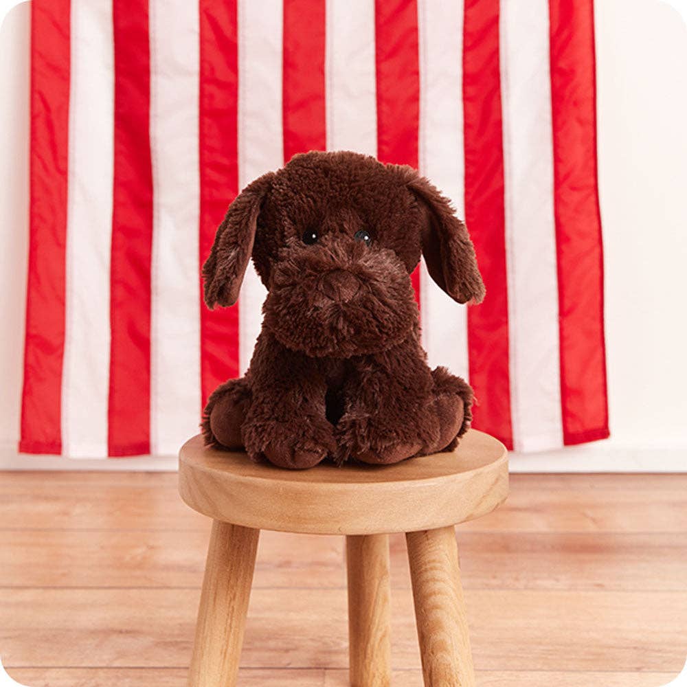 Chocolate brown plush labrador dog perched on a round wooden stool