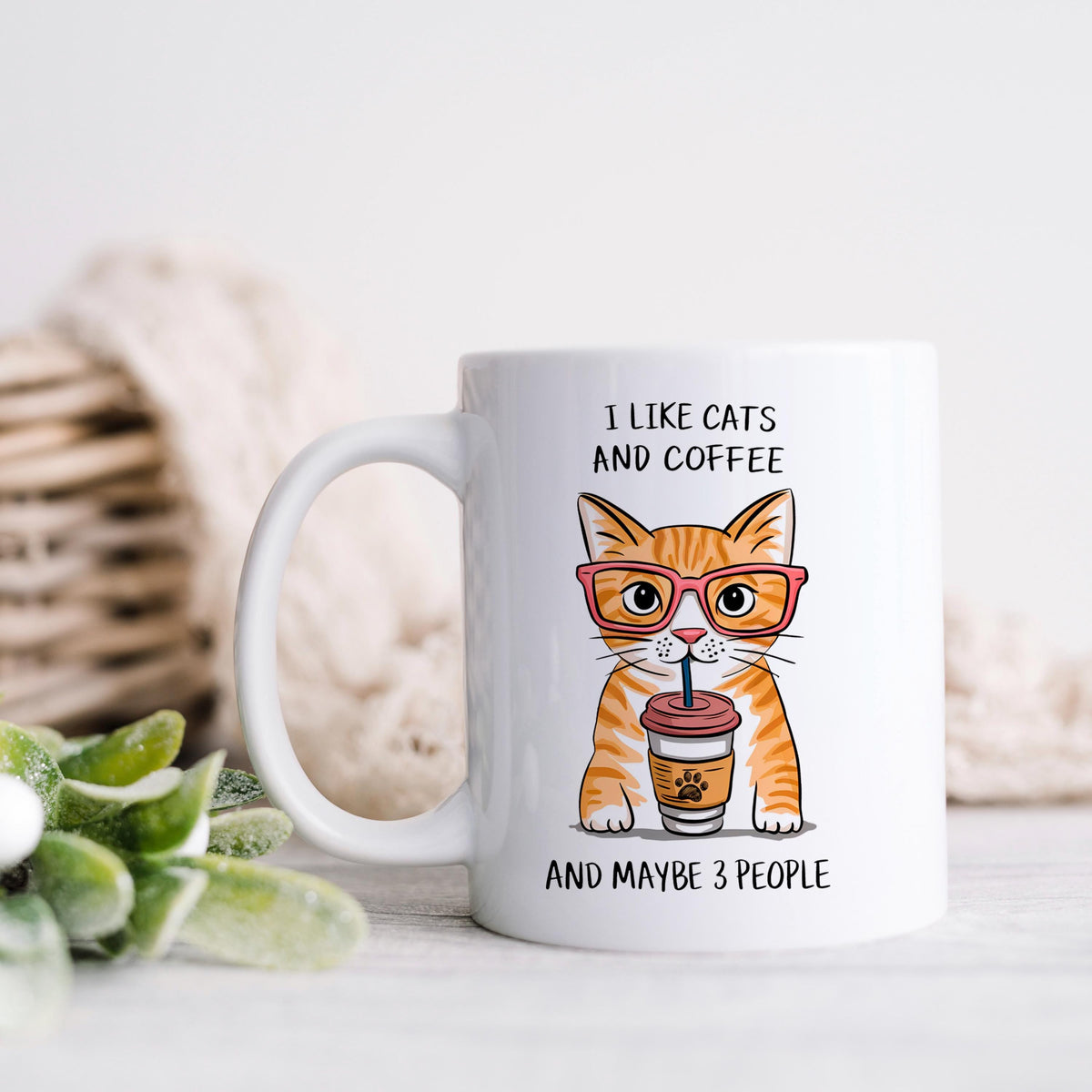 White ceramic mug with orange tabby cat graphic and “And maybe 3 people”