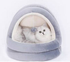 Light gray cat cave bed with inner white cushion and rounded opening, pet curled inside
