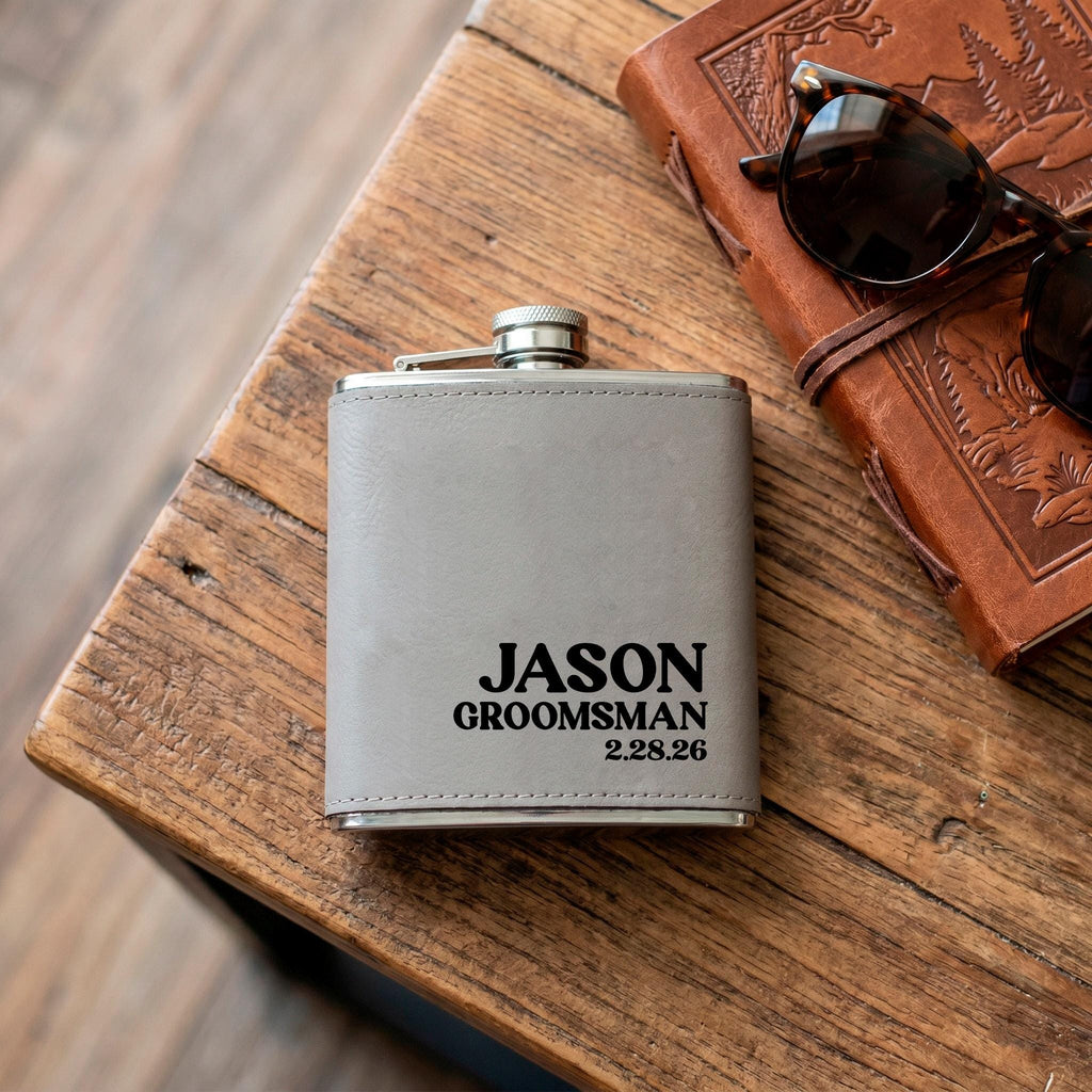 Engraved stainless steel flask with gray leather sleeve, name JASON GROOMSMAN on front