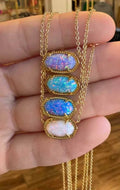 Gold-tone pendant necklace with four oval multicolor opal-like stones