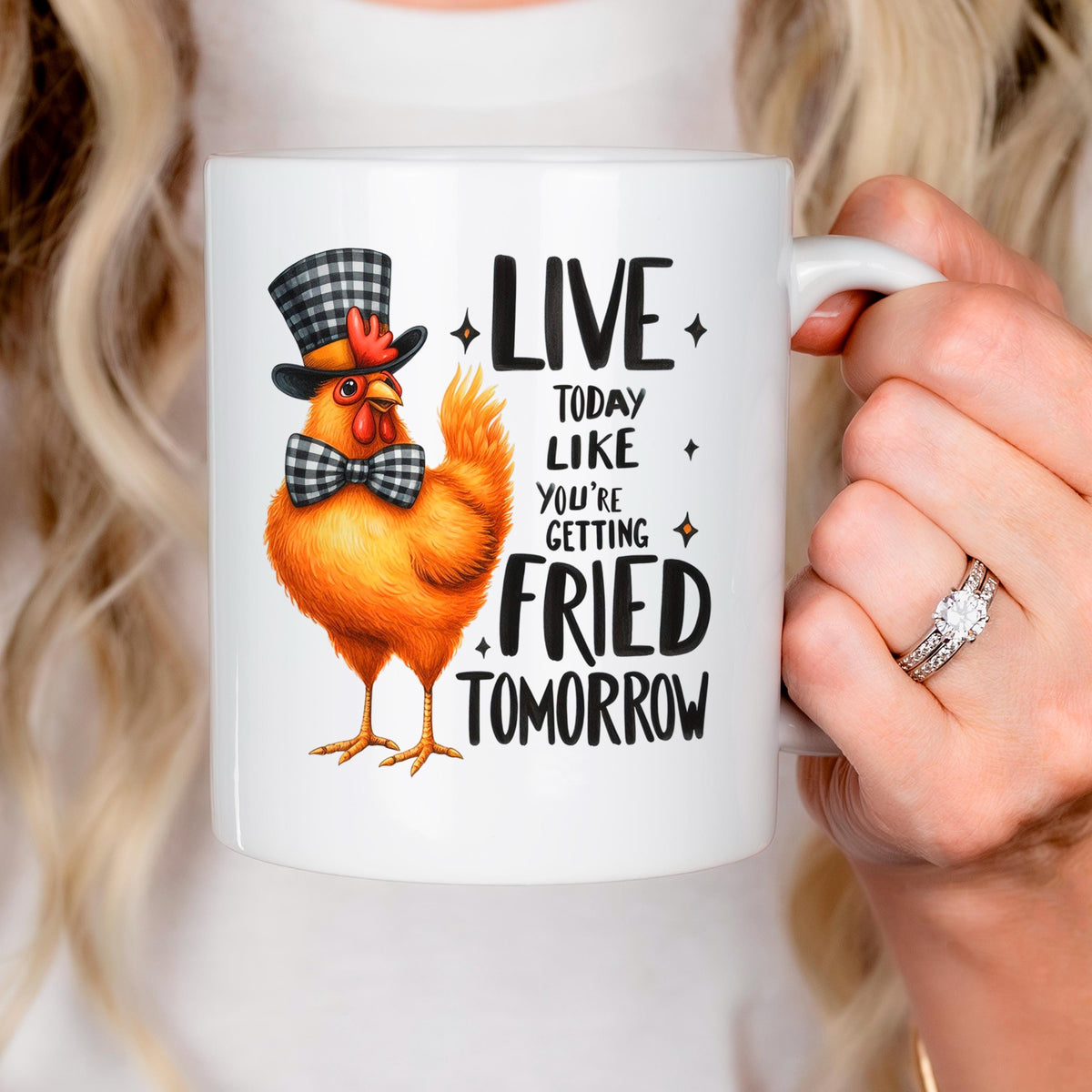 Hand holding white ceramic mug with orange cartoon chicken and LIVE…FRIED TOMORROW slogan