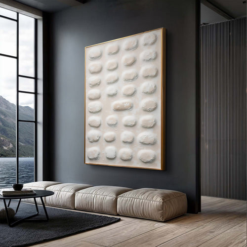 Abstract textured wall art with raised white ovals in a gold frame