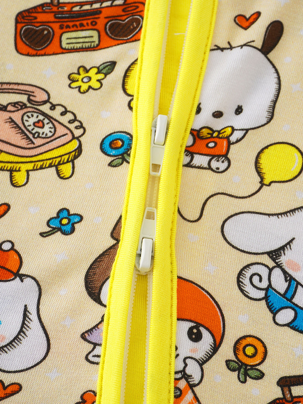 Baby romper front zipper close-up with yellow placket; cute character faces and icons print
